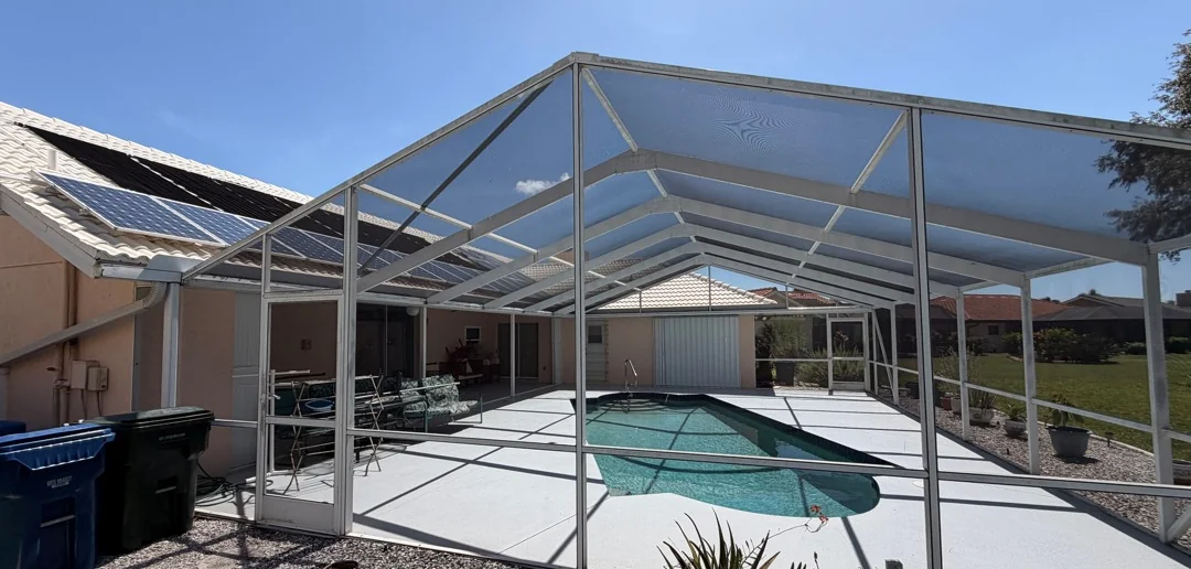 Pool cage in Venice before restoration, aluminum frame dull and most screen panels missing