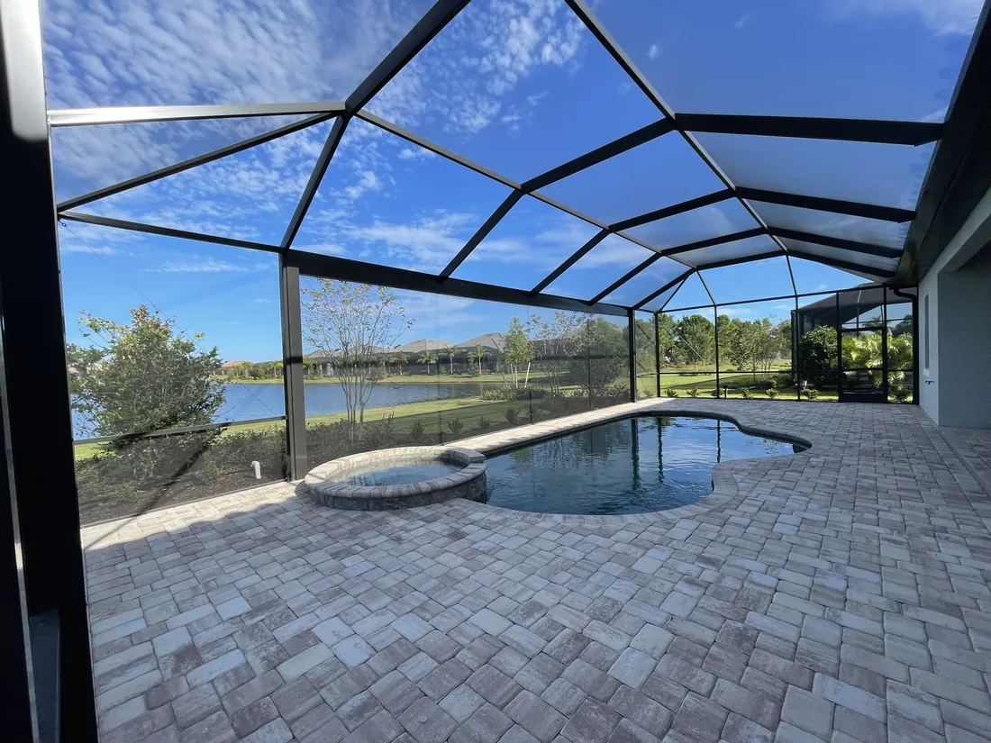 Paver pool deck installed inside a screened pool cage in Sarasota, Florida