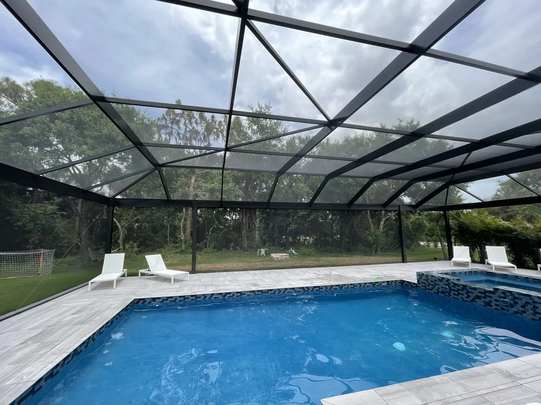 New pool cage construction with bronze aluminum framing over a rectangular pool in Lakewood Ranch, Florida