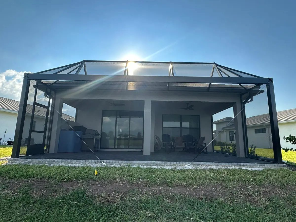 Aluminum screen room addition attached to the rear of a Florida home in bright sunlight